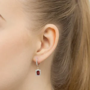 Cercei Marcella din aur galben cu garnet și diamante purtați pe ureche.